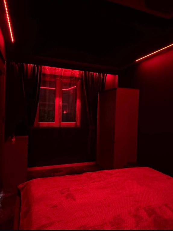 a red room with a bed and a window at La Garson in Borsa