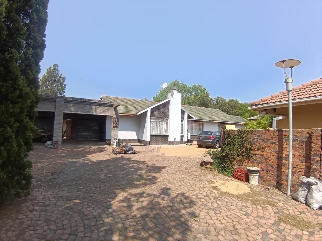 a house with a car parked in front of a driveway at 12 Bologna B&B in Evander