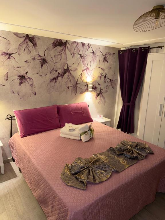 a bedroom with a pink bed with clothes on it at Palazzo Carignano in Chioggia
