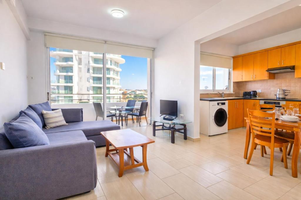 a living room with a couch and a table at Sunset Poolside Apartment with Pool facility in Larnaca