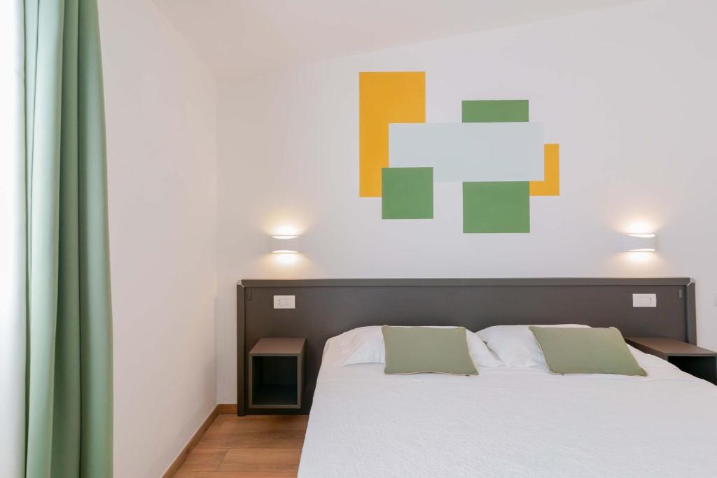 a bedroom with a bed and a painting on the wall at Admayora Guest House in Villasimius