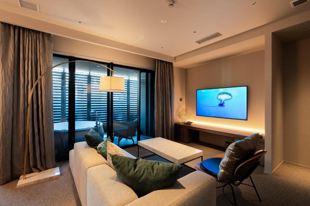 a living room with a couch and a tv at THE skM TOKYO HOTEL & DINING in Tokyo