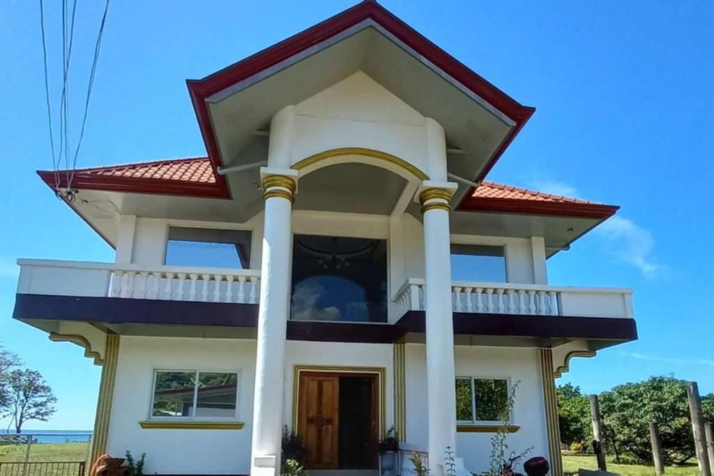 a house with a porch and columns at Seven Waves Beachfront Residence - La Union in Bagbag Oeste