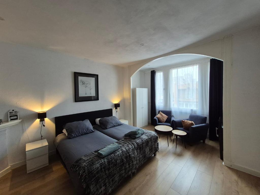 a bedroom with a bed and a living room at Studio Slijterij Zandvoort in Zandvoort