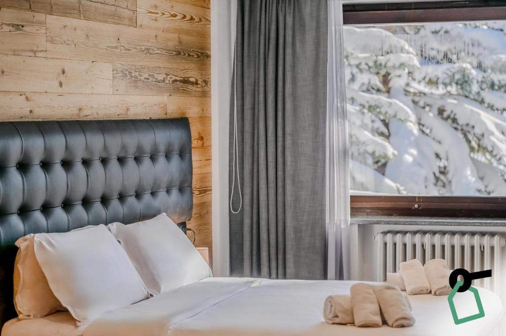 a bedroom with a bed with two towels on it at Hotiday Sestriere Ski Run in Sestriere