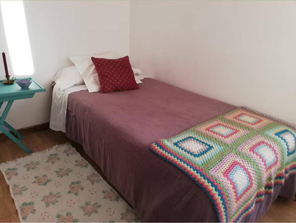 a bedroom with a bed with a blanket and a table at Casa Salvia in Castelanes