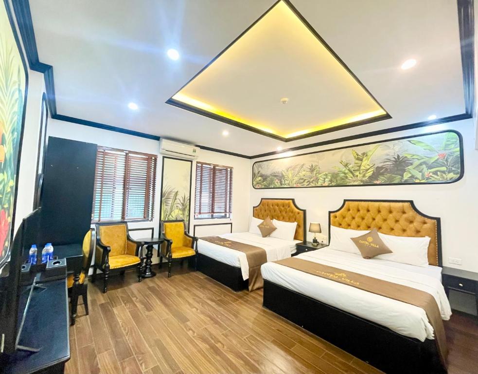 a hotel room with two beds and a desk at Capital CauGiay Hotel in Hanoi