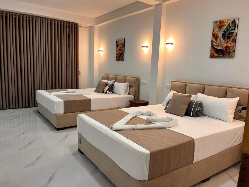 a hotel room with two beds in a room at Diyon'S Lodge in Ella