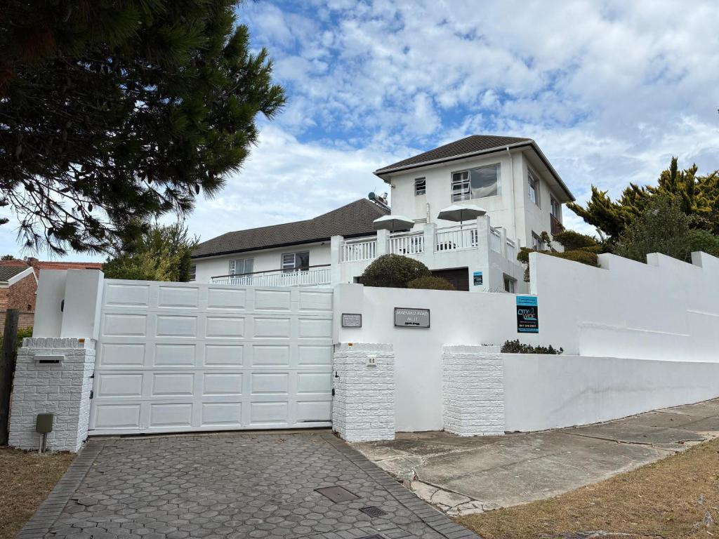 a white fence in front of a white house at Ameni Air B&B in Gqeberha