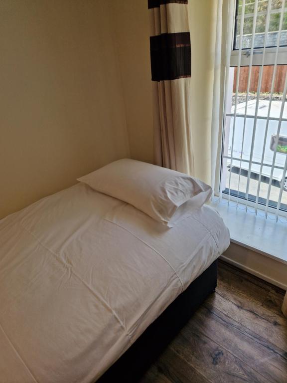 a bed sitting in a room with a window at Ynyscedwyn Arms in Ystradgynlais