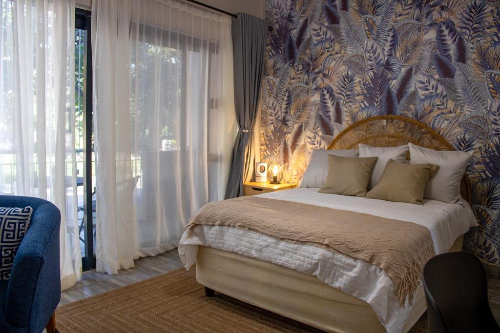 a bedroom with a bed with a blue and white wallpaper at Dawn's Place in Harare