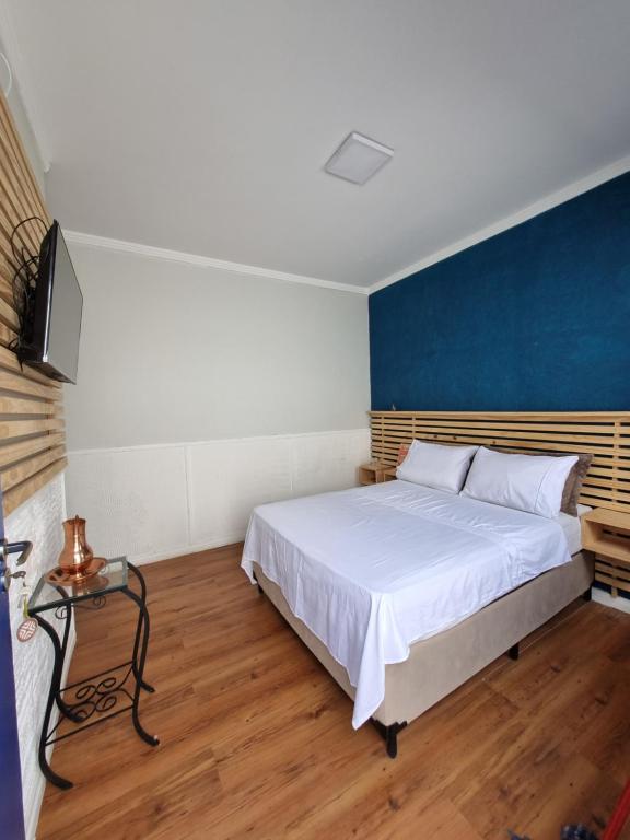 a bedroom with a bed and a blue wall at Loft em Butantã, próximo a USP in São Paulo