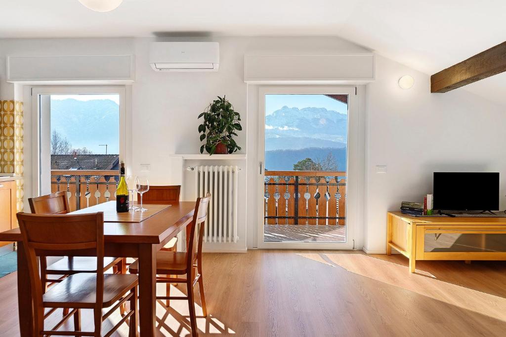 a dining room with a table and chairs and a television at The View in Levico Terme