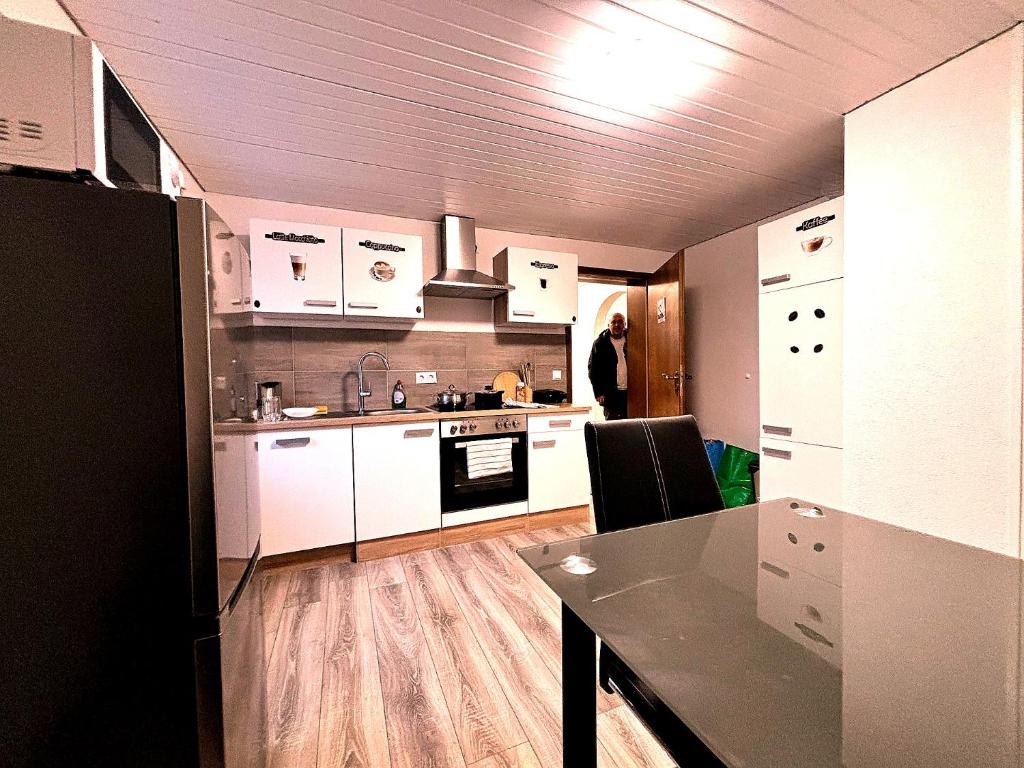 a kitchen with white cabinets and a table in it at Room4U in Memmingen
