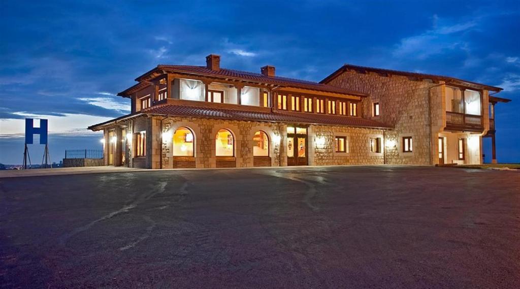 a large brick building with an empty parking lot at Hotel Verdemar by Grupo A Cobijo in Lamadrid