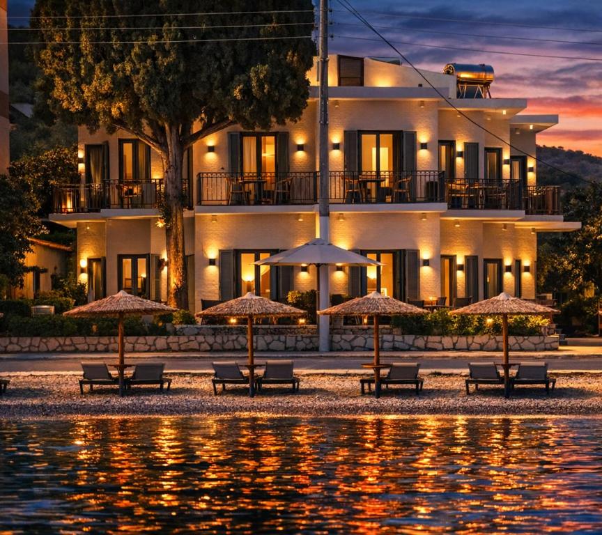 a hotel with tables and umbrellas in front of a building at Okeanis Hotel Tyros in Tyros