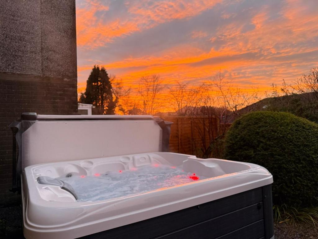 a bath tub with a sunset in the background at Skiddaw Heights in Keswick