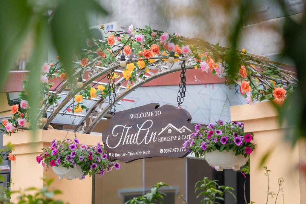 a sign for a flower shop with flowers in buckets at ThuAn Homestay Hoa Lư in Ða Gia