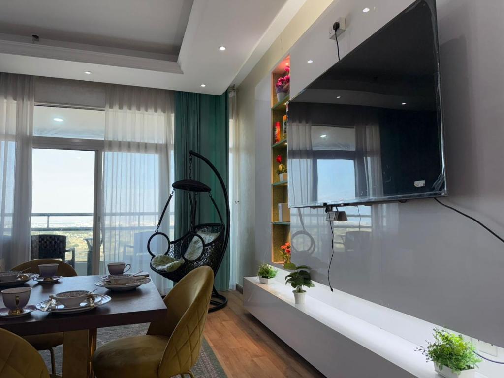 a living room with a table and a television on a wall at الهورايزون in Ajman 