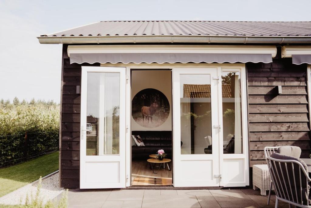a house with white doors and a patio at Huize Henk in Emst