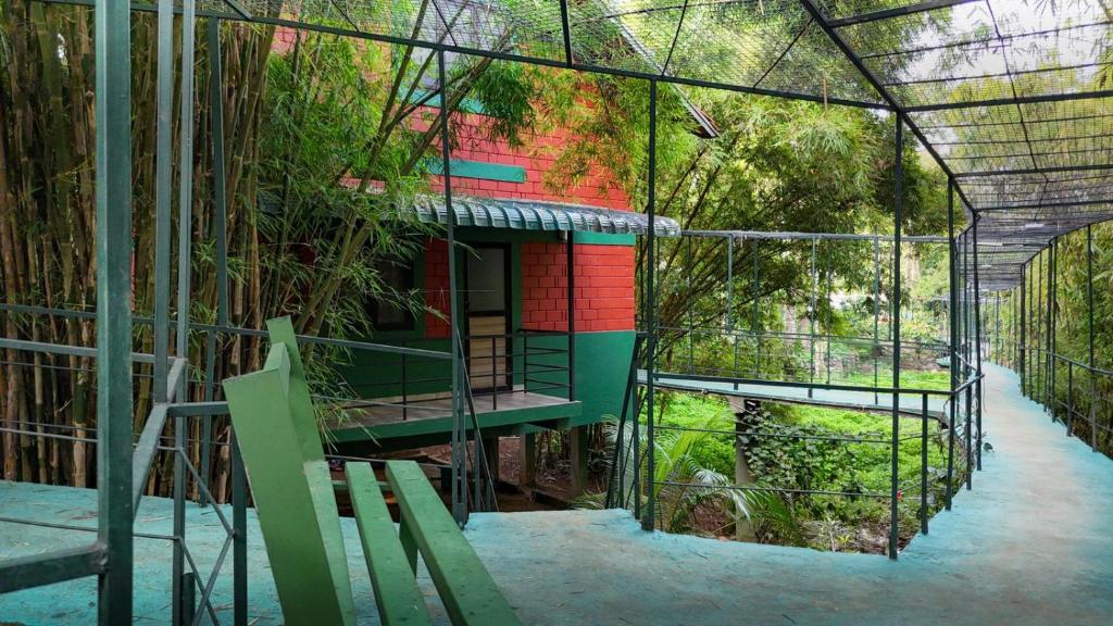 a cage with a house in the middle of a garden at Bamboo Planet Resort in Vythiri