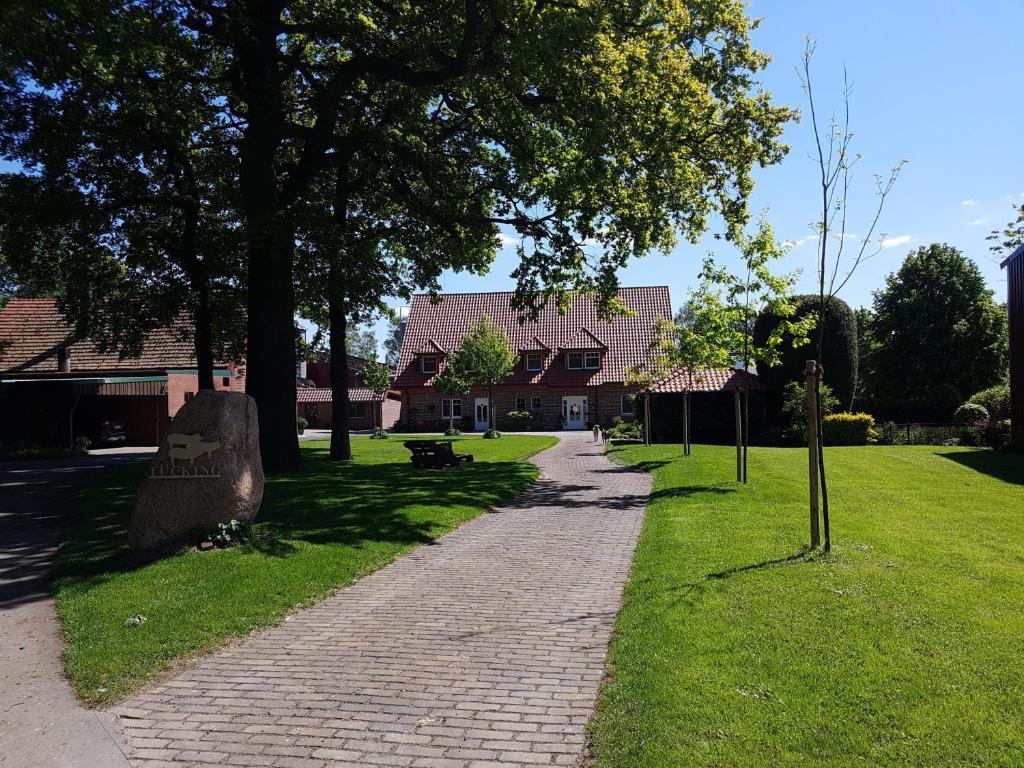 a brick path in a park with trees and a building at Omas Stübchen - Monteurwohnung auf dem Land in Borken