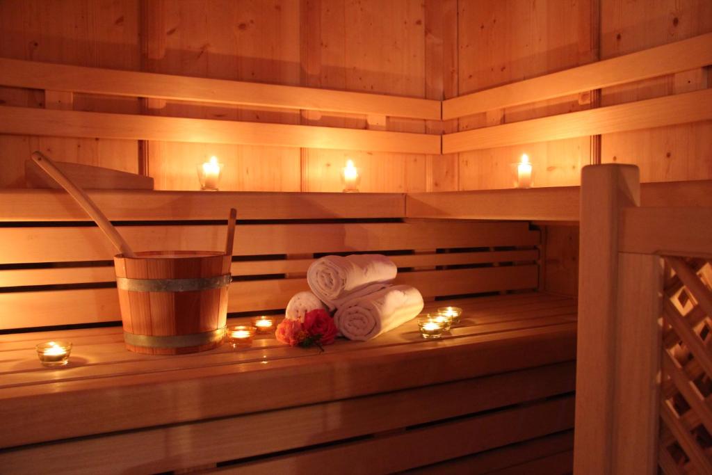 a sauna with candles and a drink and towels at Hotel Lory in Pinzolo