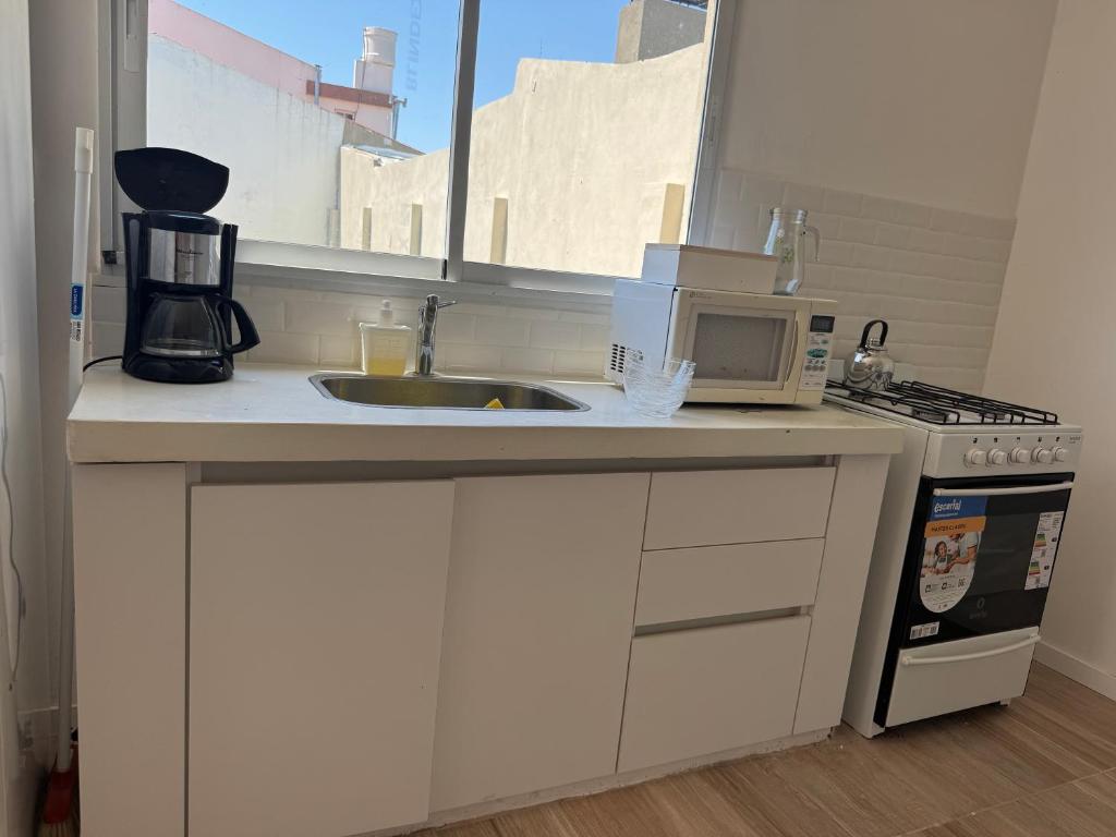 a kitchen counter with a sink and a microwave at Ms3M casa in San Pedro