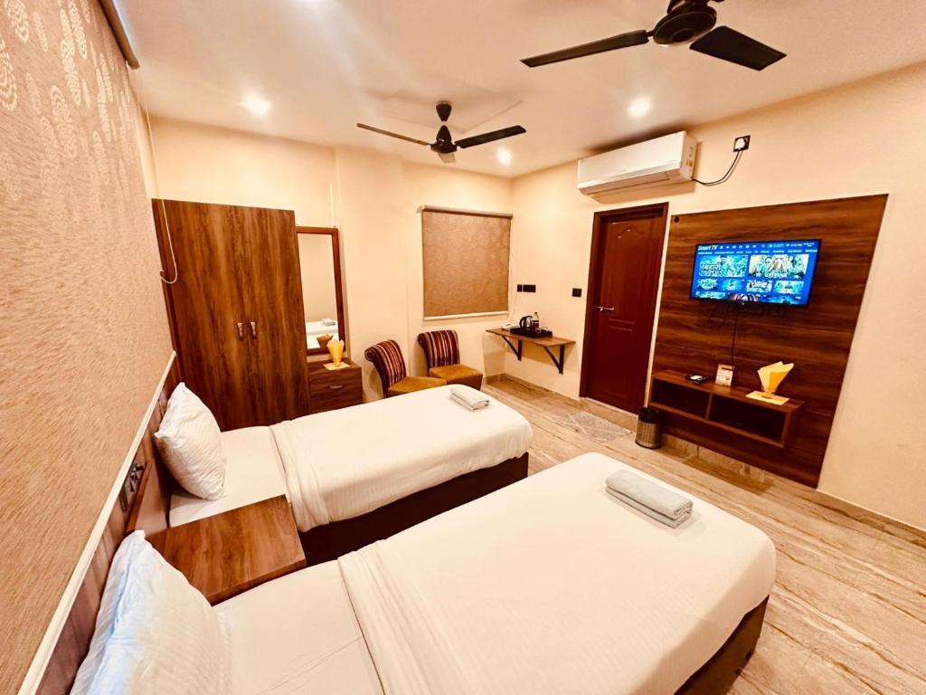 a hotel room with two beds and a flat screen tv at Hotel Windsor Plaza in Hyderabad