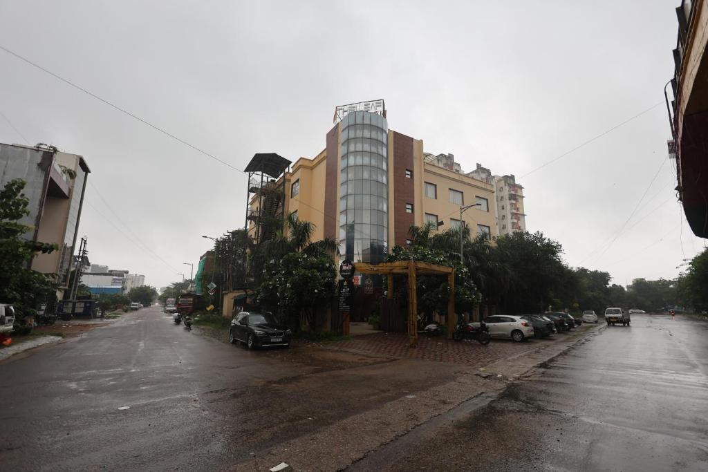 an empty street with cars parked on the side of a building at Hotel Leaf Inn in Lucknow
