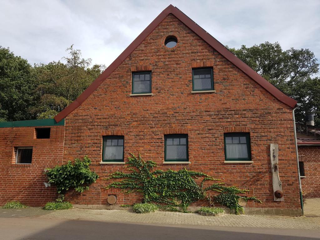 a red brick building with a triangular roof at Alte Werkstatt - Monteurwohnung auf dem Land in Borken