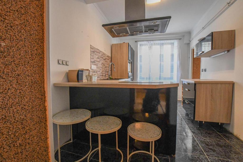 a kitchen with three stools under a counter in a room at La lukas in Mussy-sur-Seine