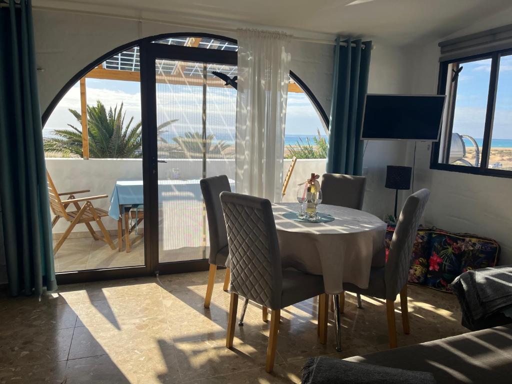 a dining room with a table and a view of the ocean at Tiki Apartment Audrey in Playa Jandia