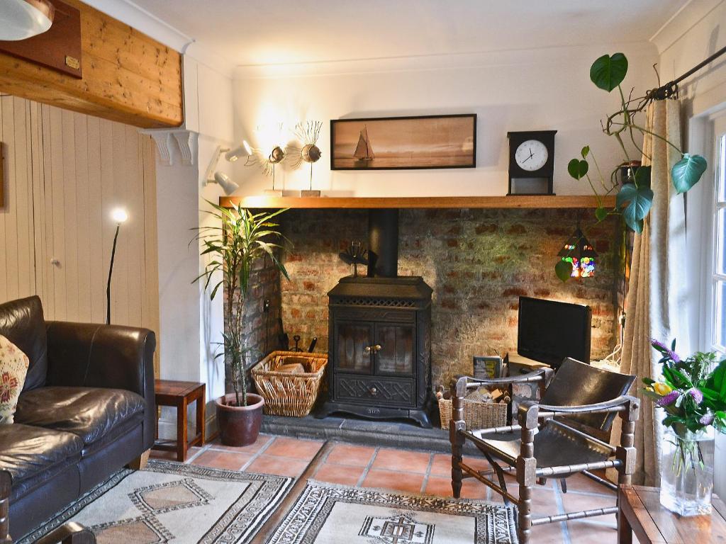 a living room with a fireplace and a couch at Gareside Lodge in Rhu