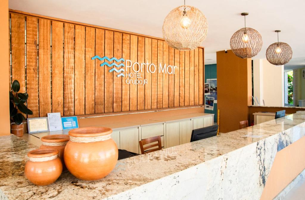a lobby with two large vases on a counter at Porto Mar Hotel in Porto Seguro