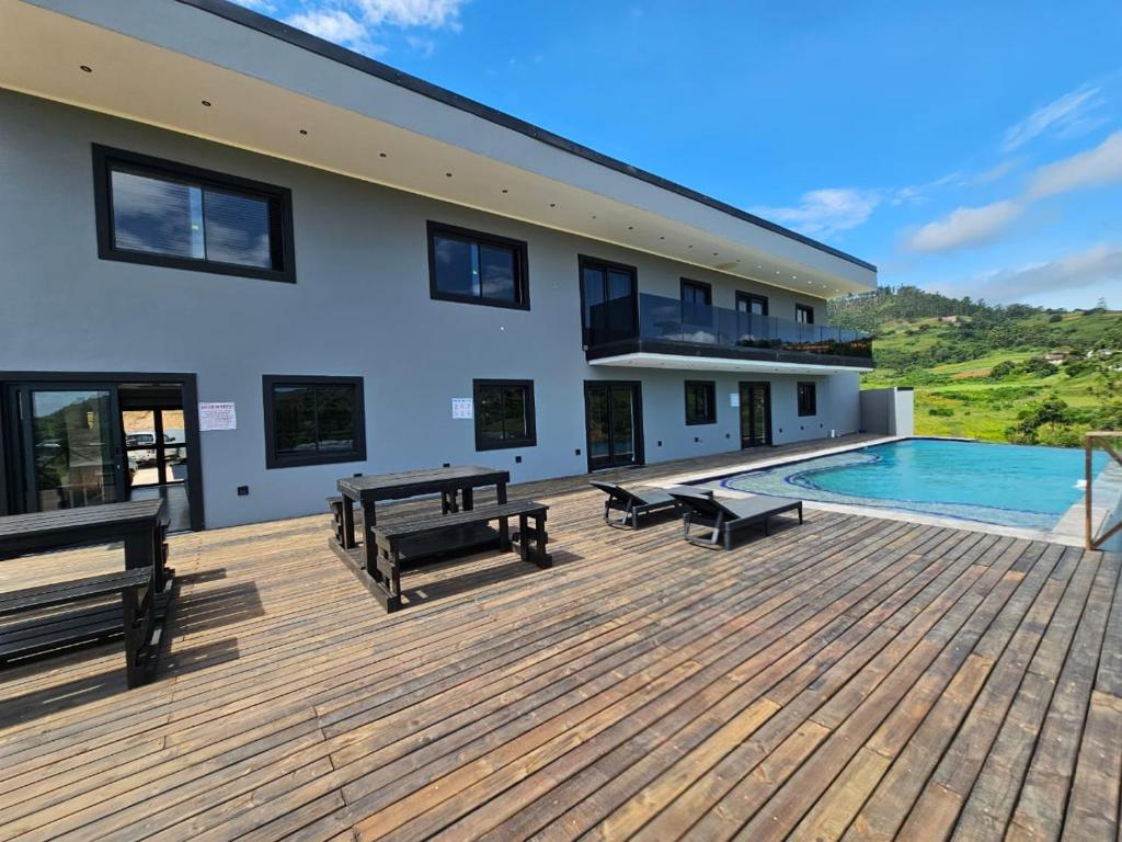 a house with a wooden deck with a swimming pool at Pegasus Peak Lodge in Drummond