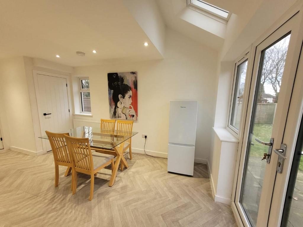 a dining room with a table and a refrigerator at Ideal Lodgings in Radcliffe in Radcliffe