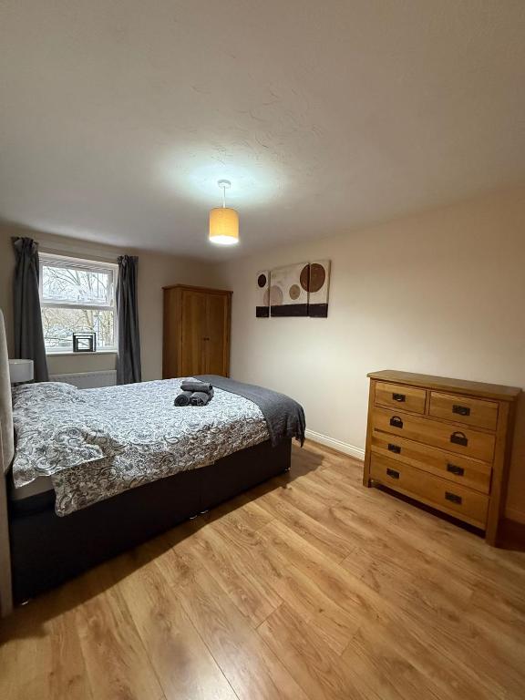 a bedroom with a bed and a wooden dresser at Beaumont Court in Coventry