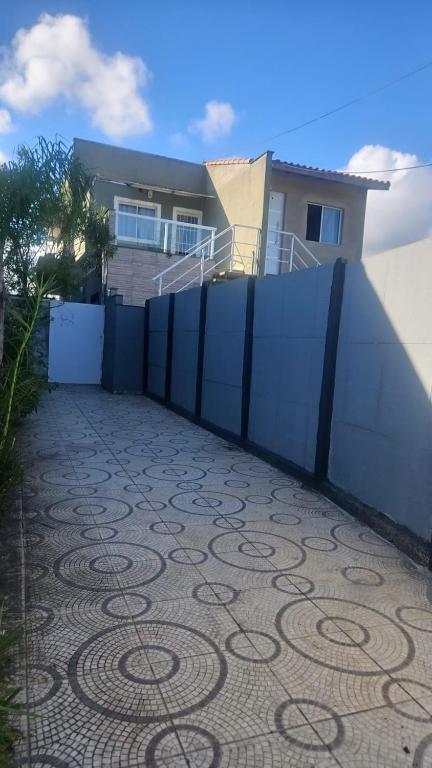 a fence in front of a house with a carpet at Casa Itanhaém Praia Cibratel in Itanhaém