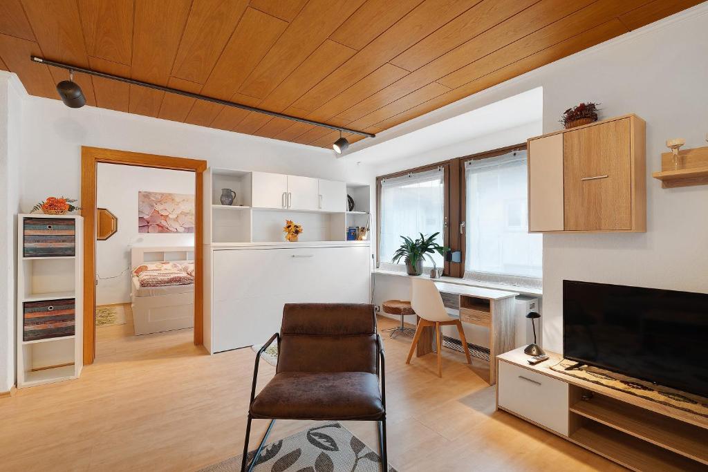 a room with a chair and a desk with a television at Ferienwohnung Eva Maria in Pforzheim