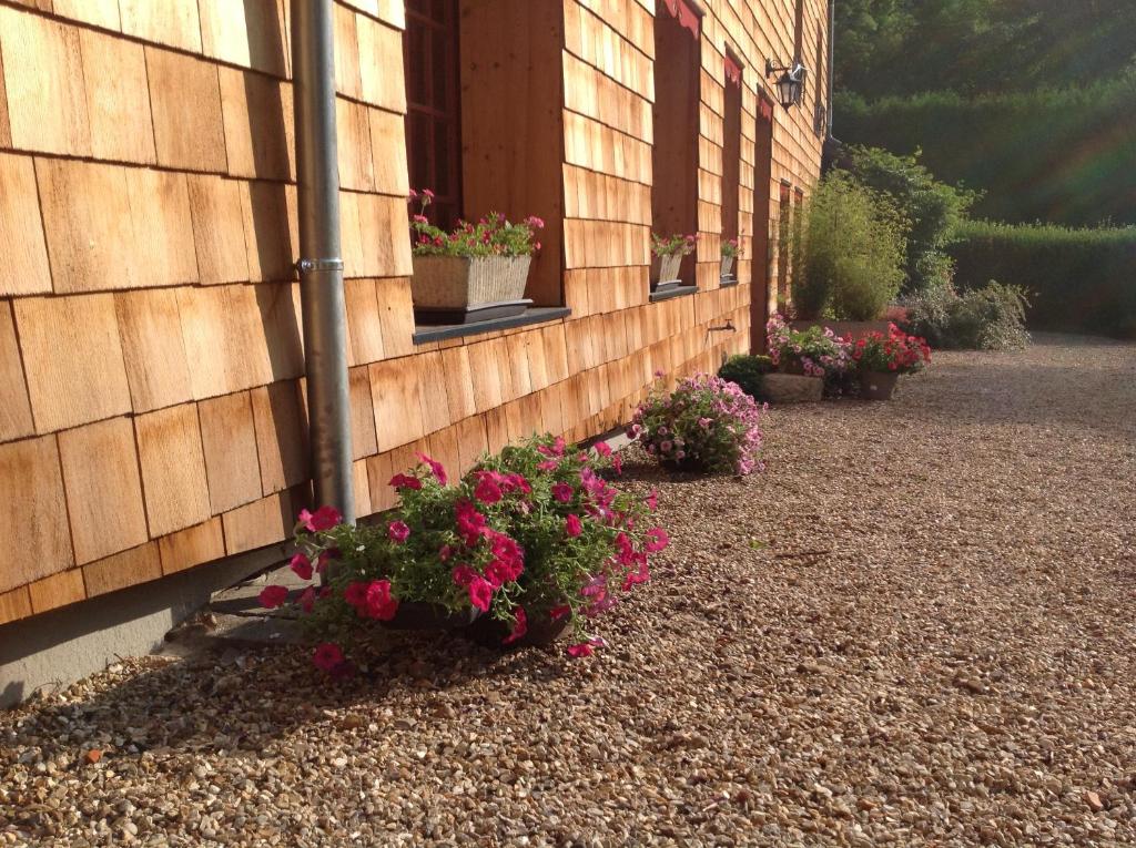 a building with flowers on the side of it at La Forge de Paul et Virginie in Mainneville