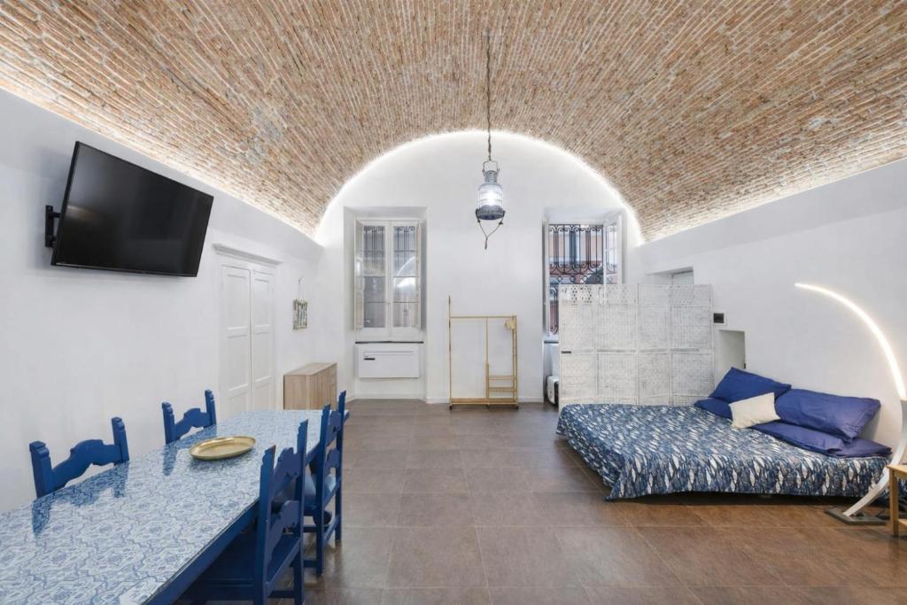 a living room with a table and a couch at Seafront, Large Studio on the Beach with AC and WiFi in Pietra Ligure