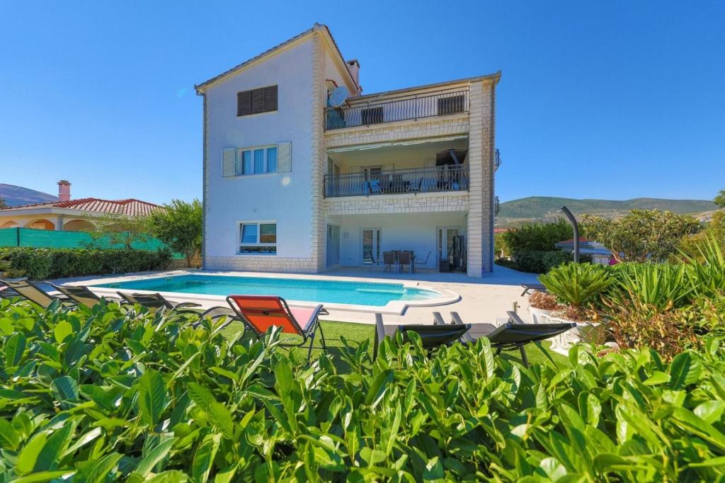 a villa with a swimming pool in front of a house at Villa Olivia Trogir in Trogir