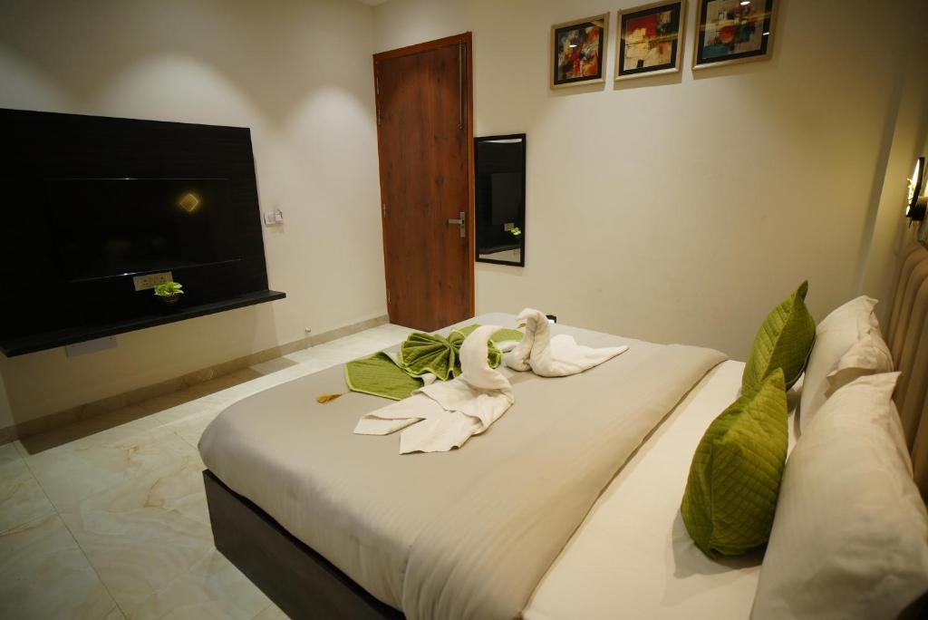 a bedroom with a bed with towels on it at The Leaf Farm in Ludhiana