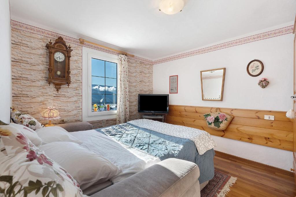 a bedroom with a bed and a tv in it at Casa Zarina Well-kept Two-room in Cavalese