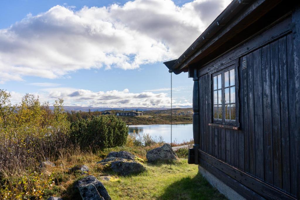 a building with a window next to a body of water at Rundetjødn 20 in Hol