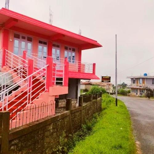 a red building on the side of a street at Za Homestay in Cherrapunji