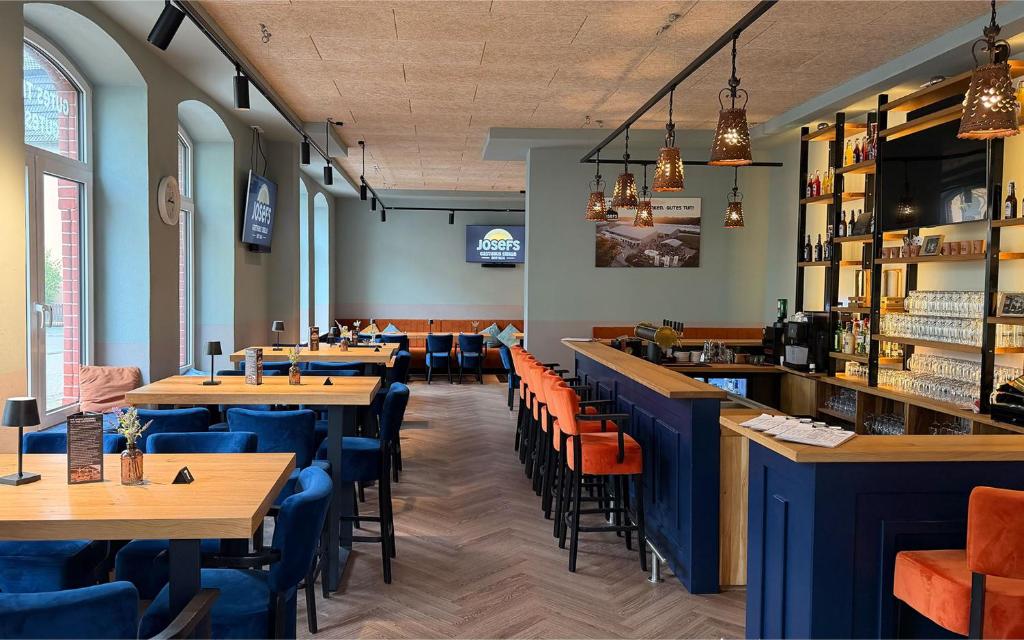 a restaurant with tables and chairs and a bar at JOSEFS Gasthaus Sibille in Schlangen