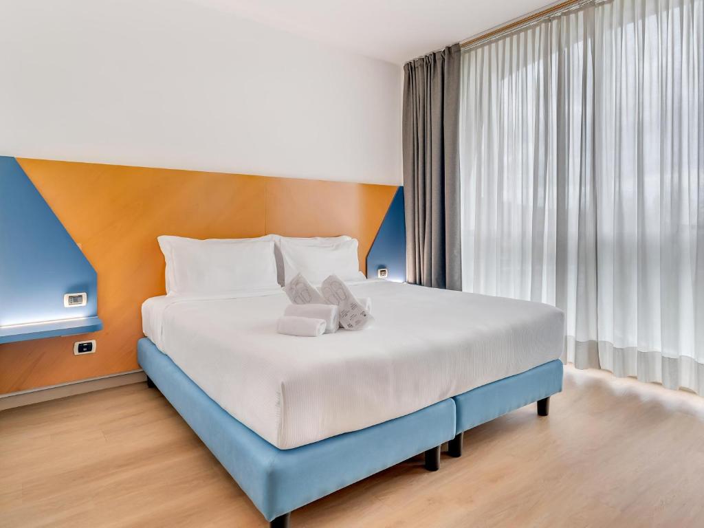 a large bed in a room with a large window at B&B HOTEL Bergamo Executive in San Paolo D'Argon