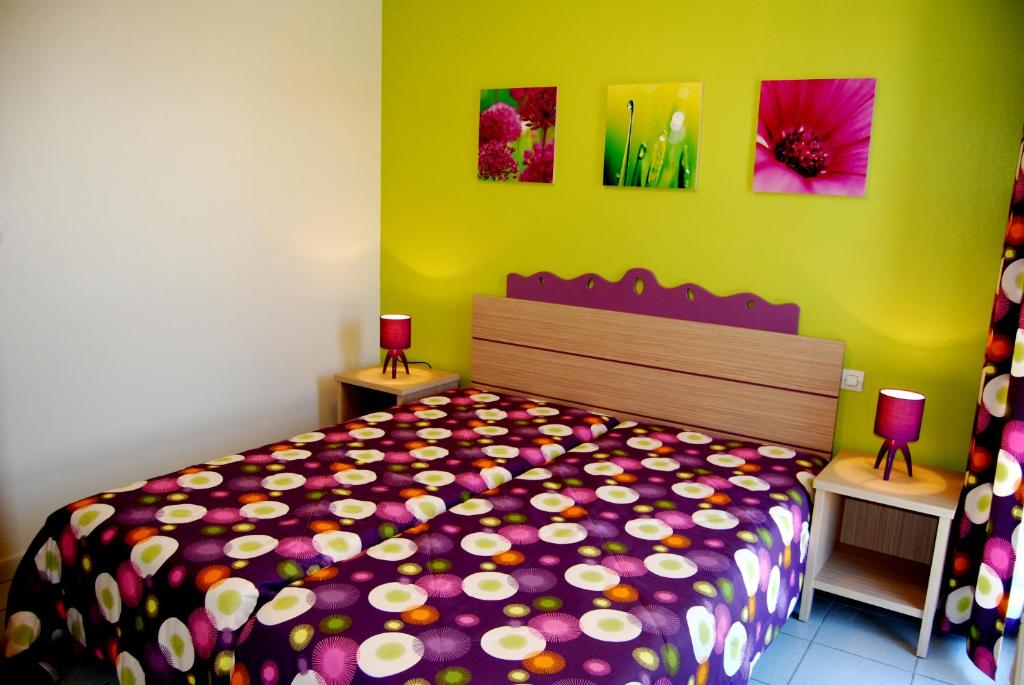 een slaapkamer met een bed met een kleurrijke sprei bij Lagrange Grand Bleu Vacances – Résidence Les Pierres de Jade in Saint-Cyprien